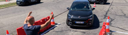 Un moniteur d'auto-école aide un élève a manoeuvrer